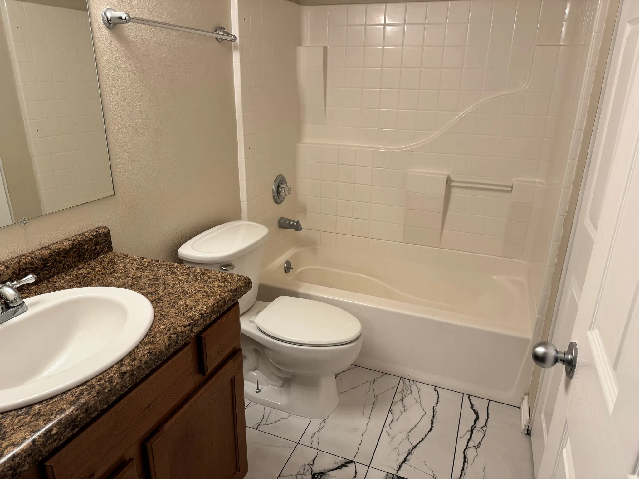 Bathroom with vanity,  shower combination, and light marble finish flooring
