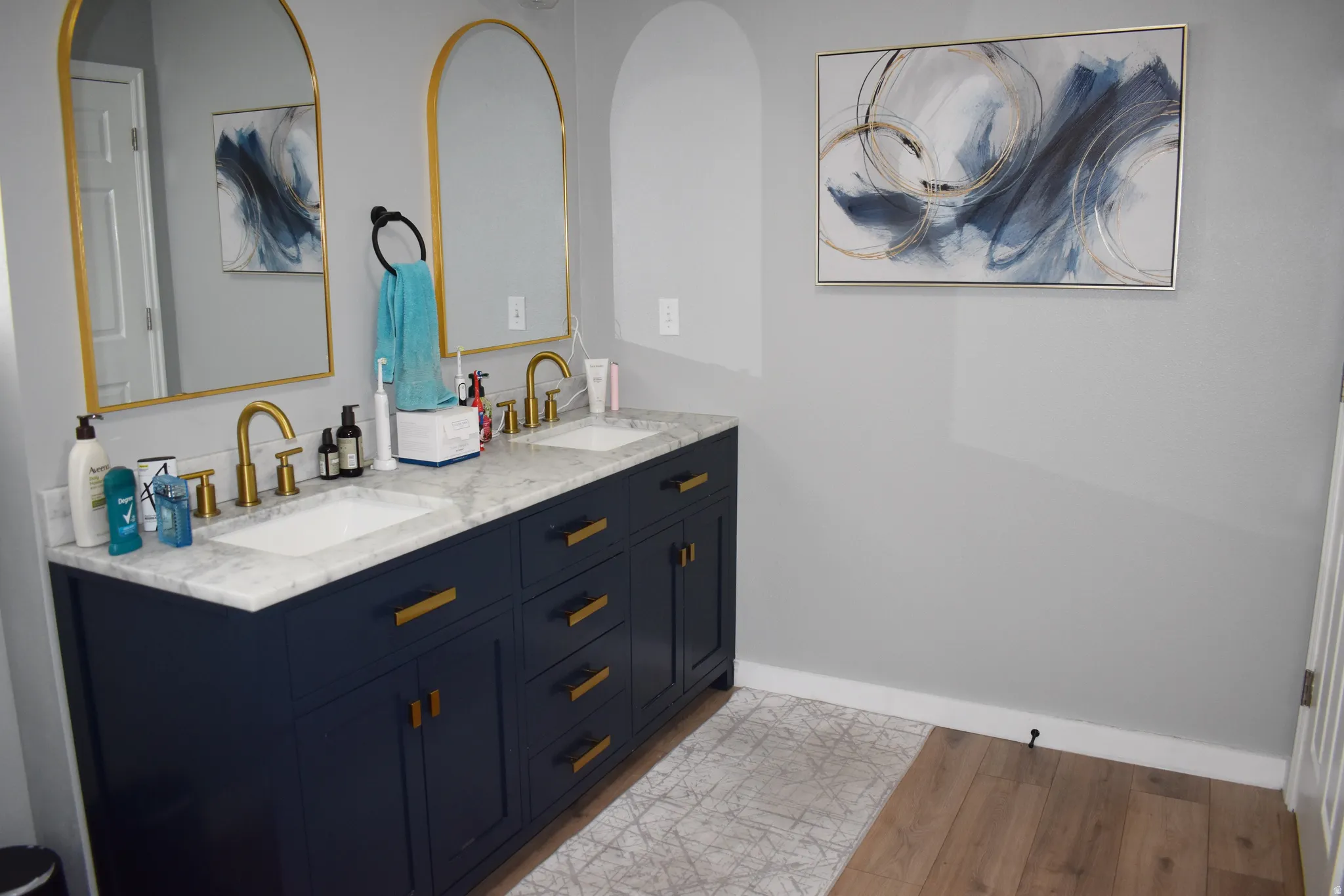 Bathroom featuring double vanity and light wood-style flooring