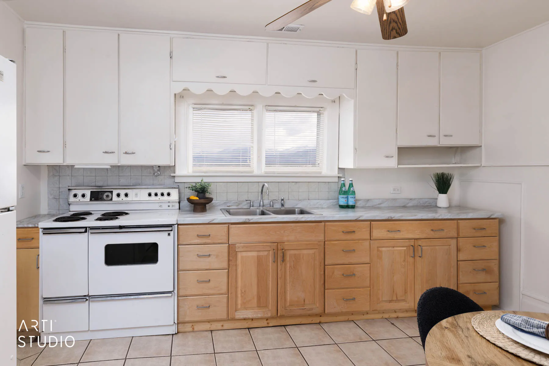 Kitchen featuring light countertops, white appliances, two tone cabinets, ceiling fan, and light tile patterned floors