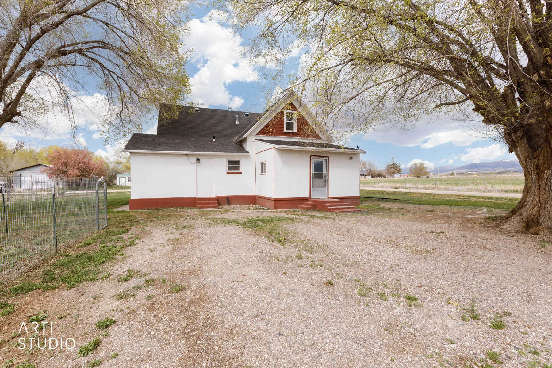 Rear view of house featuring a shingled roof and entry steps