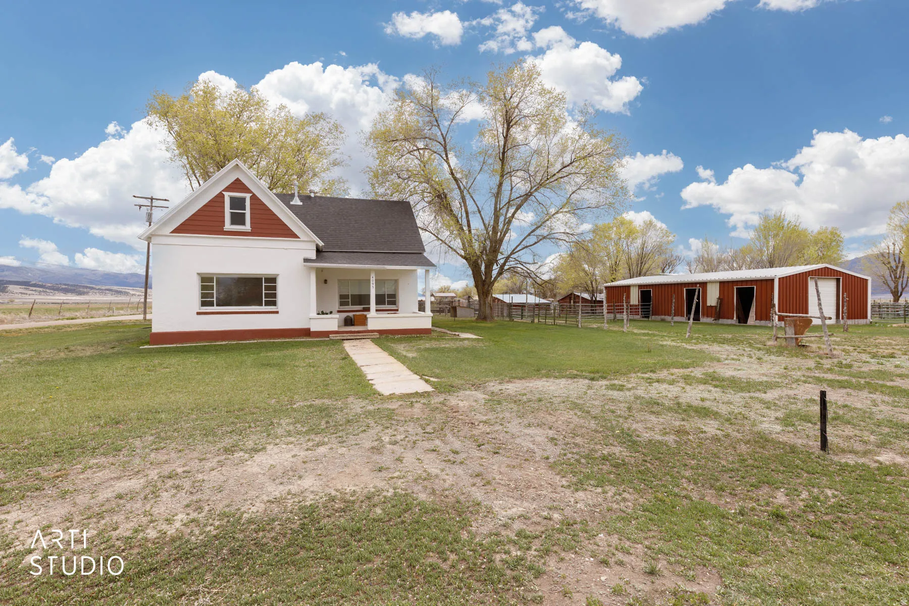 Rear view of house featuring an outbuilding, covered porch, a garage, and a mountain view