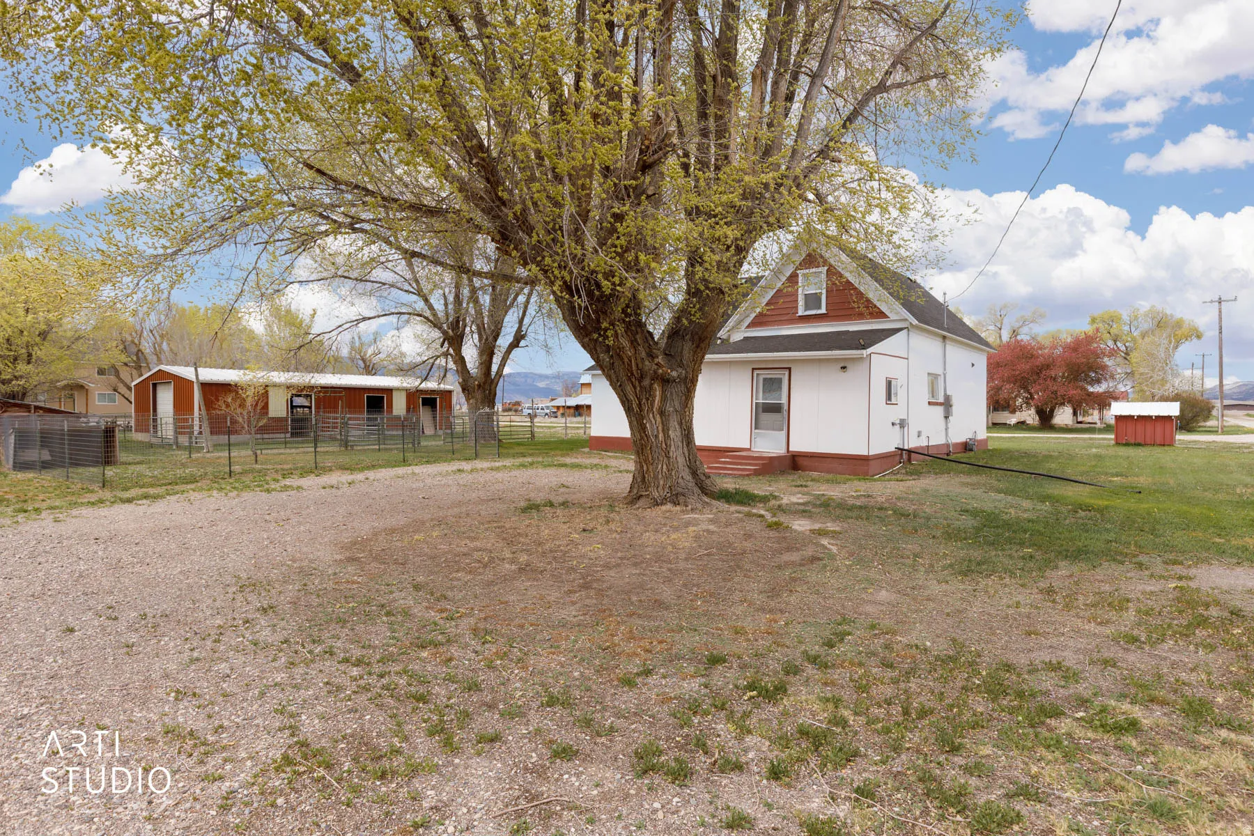 View of front of home featuring an outdoor structure, covered porch, and roof with shingles