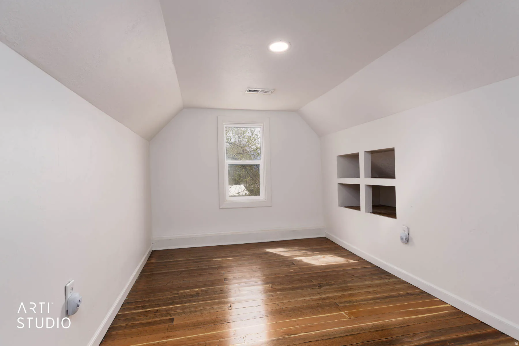 Bonus room featuring built in shelves and dark wood finished floors