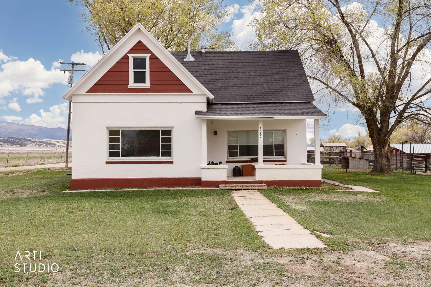 View of front facade with a front lawn, covered porch, and a shingled roof