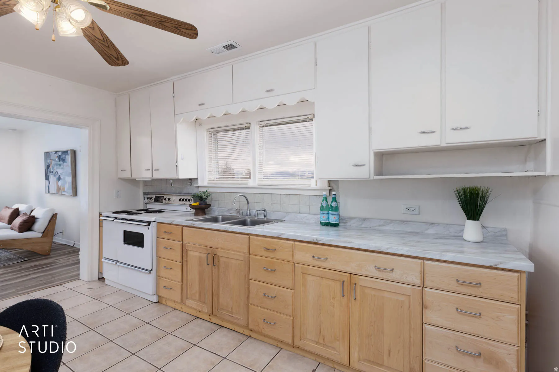 Kitchen featuring light countertops, white electric range oven, ceiling fan, dual tone cabinets, and tasteful backsplash