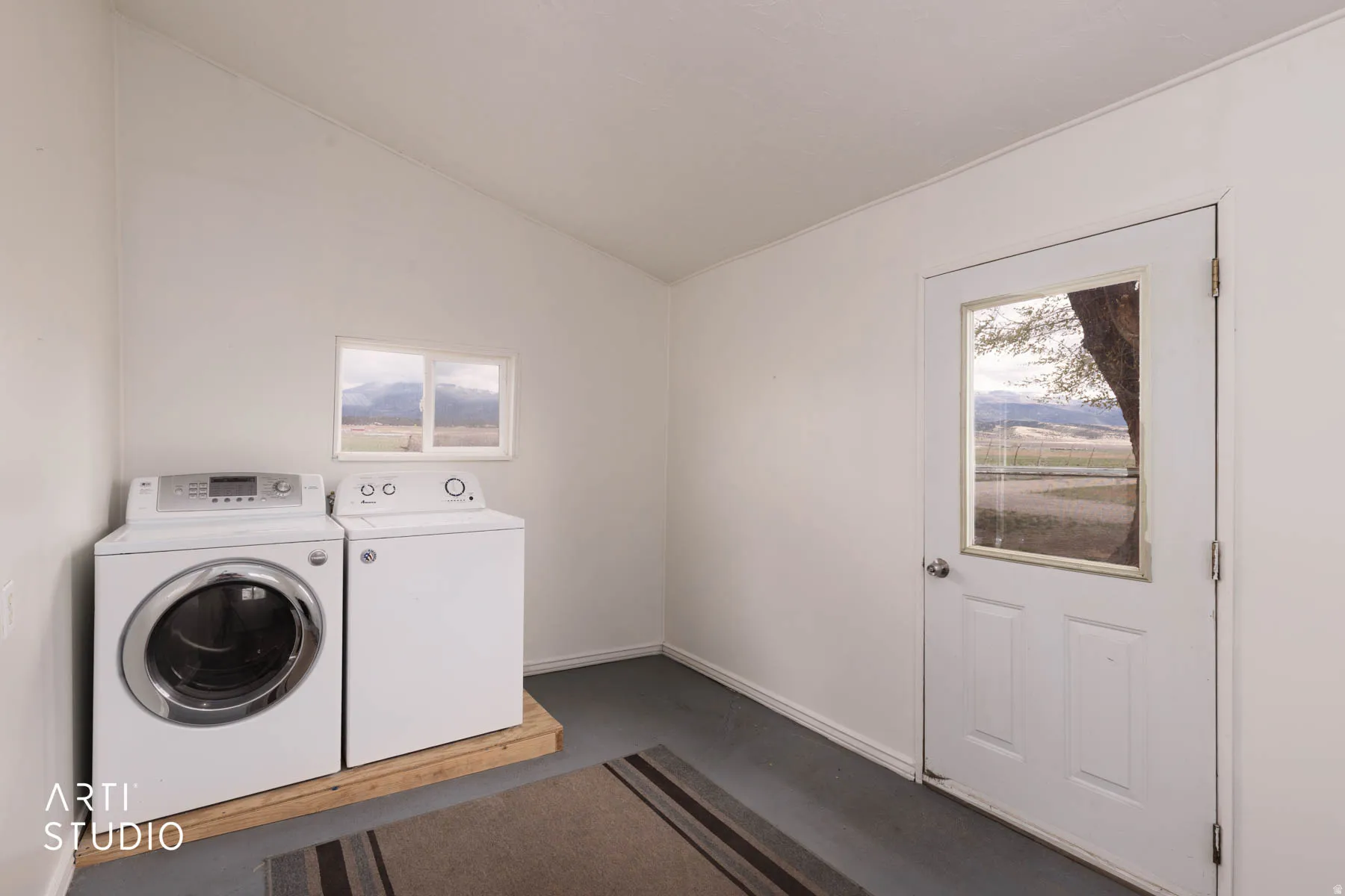 Laundry area with lofted ceiling, independent washer and dryer, and healthy amount of natural light