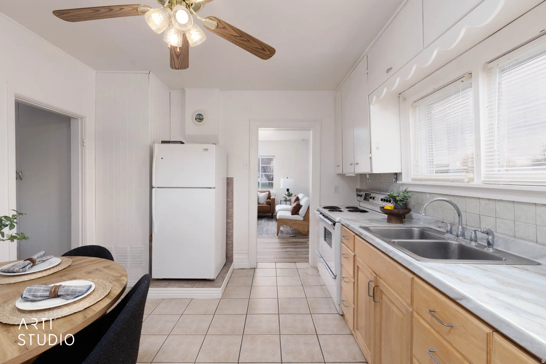 Kitchen with white appliances, light countertops, ceiling fan, backsplash, and light tile patterned floors