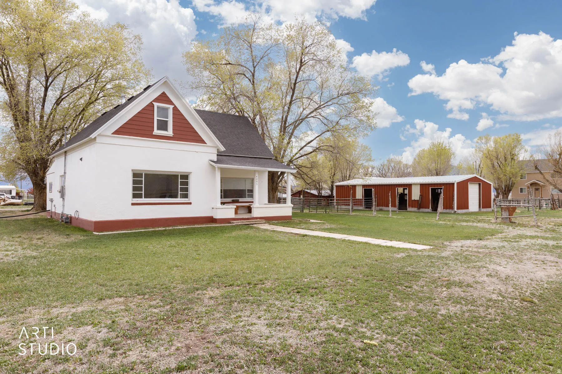 Back of house with an outdoor structure, a porch, an outbuilding, a detached garage, and a shingled roof