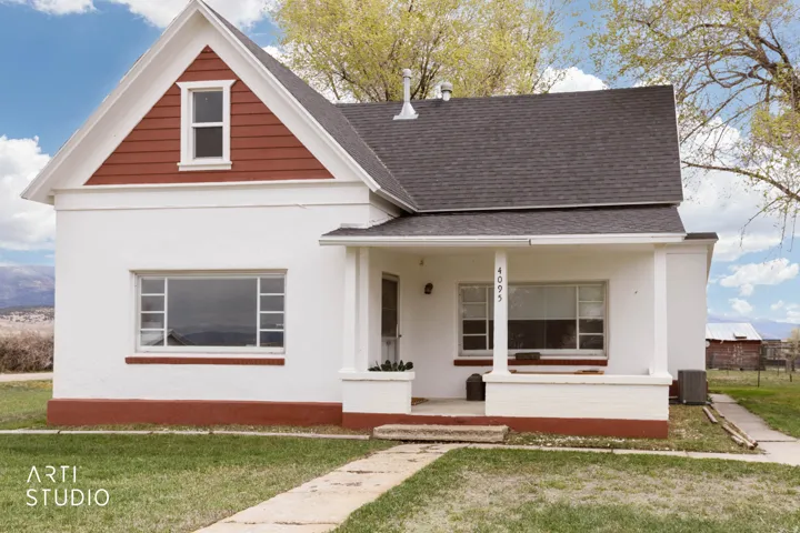 View of front of house with a porch, a shingled roof, and stucco siding