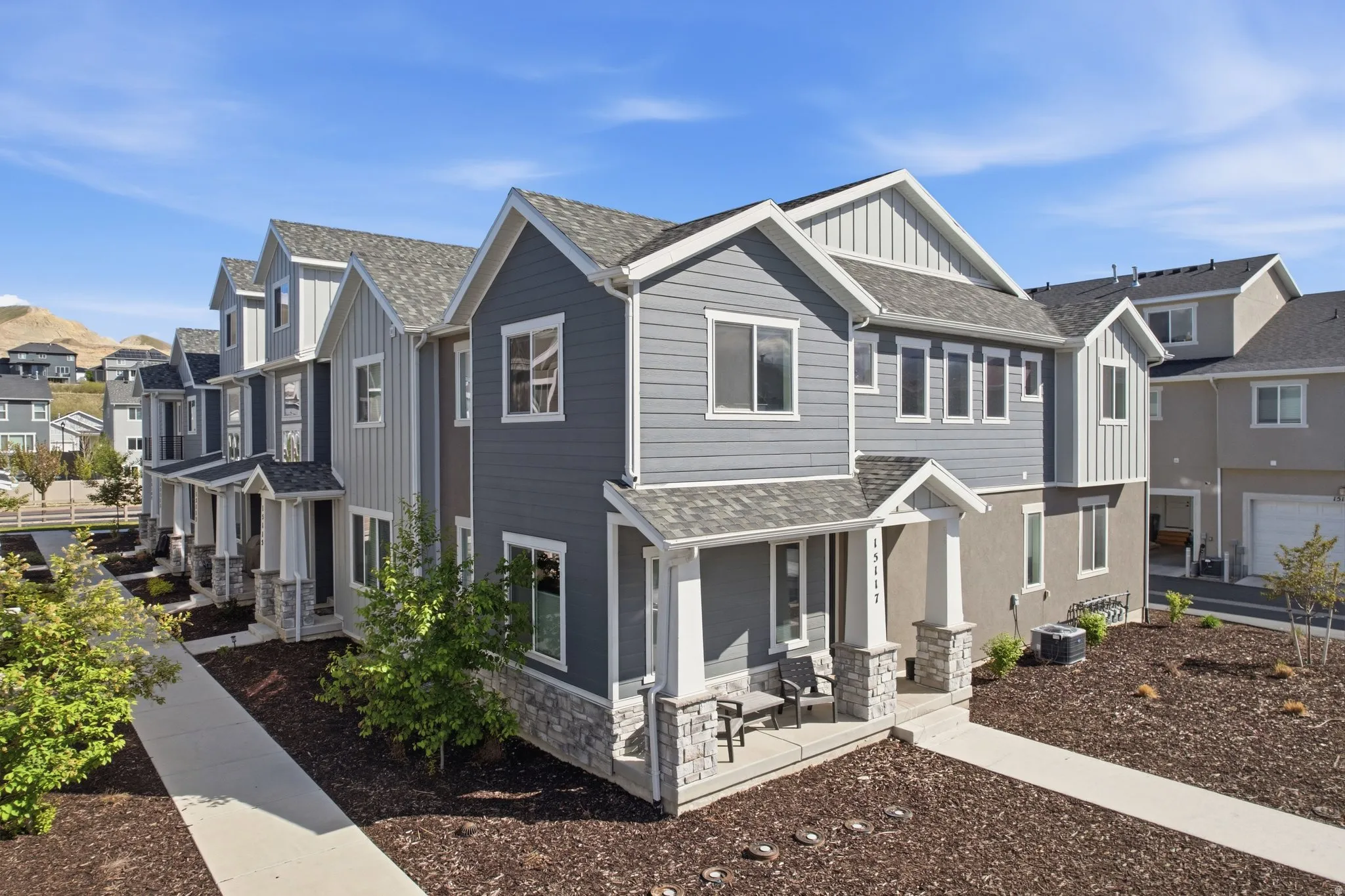 Craftsman-style house with a residential view, board and batten siding, a shingled roof, stone siding, and a porch