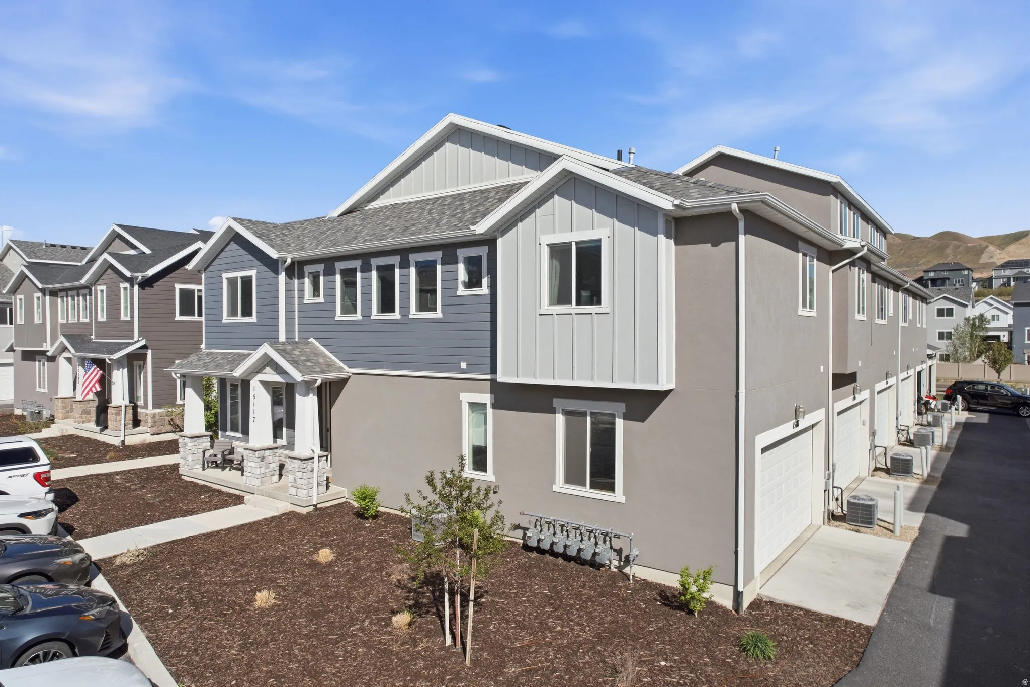 View of front of property featuring board and batten siding, a residential view, a garage, a shingled roof, and driveway