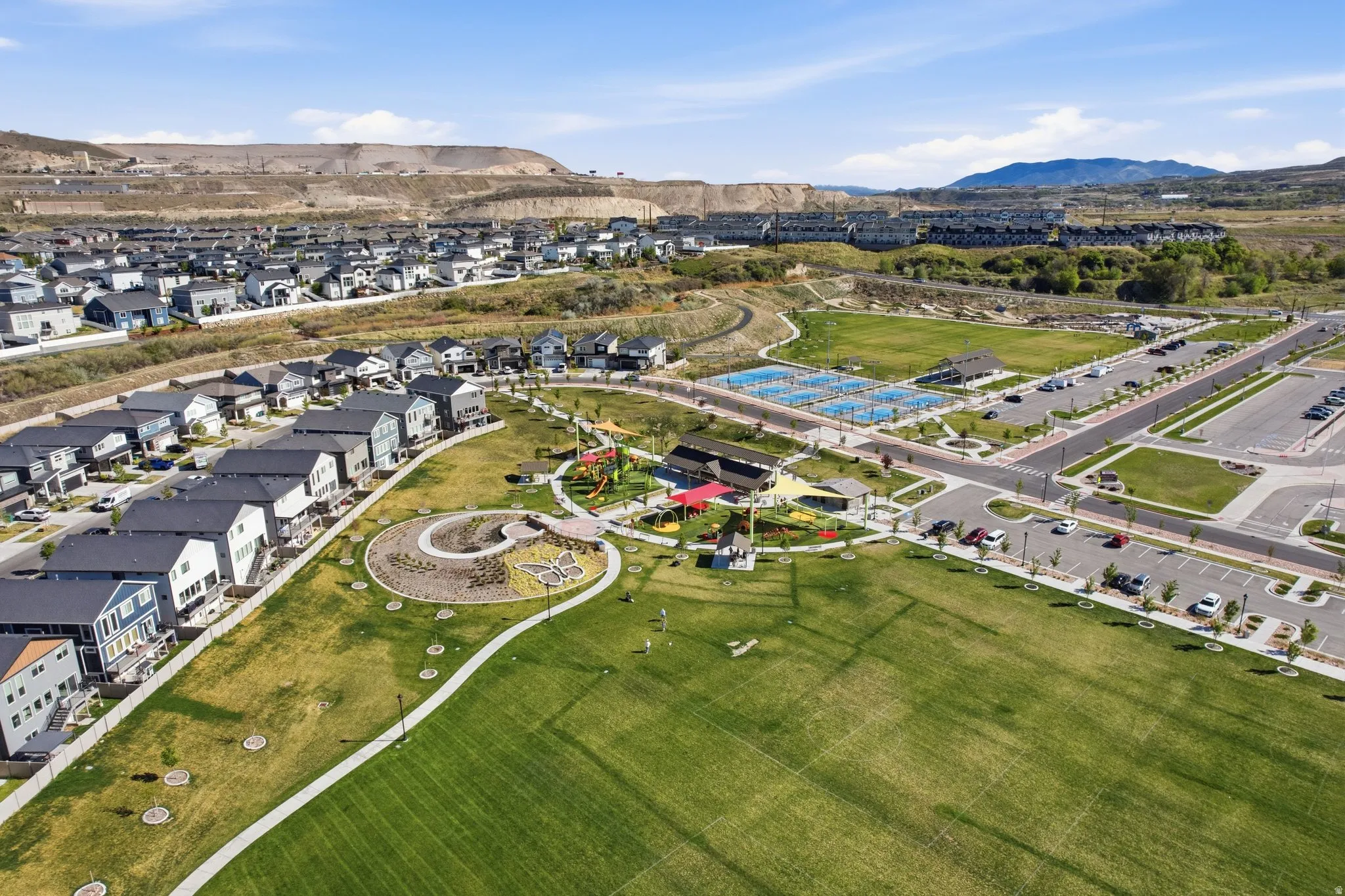 Aerial view of property and surrounding area featuring a mountainous background and nearby suburban area