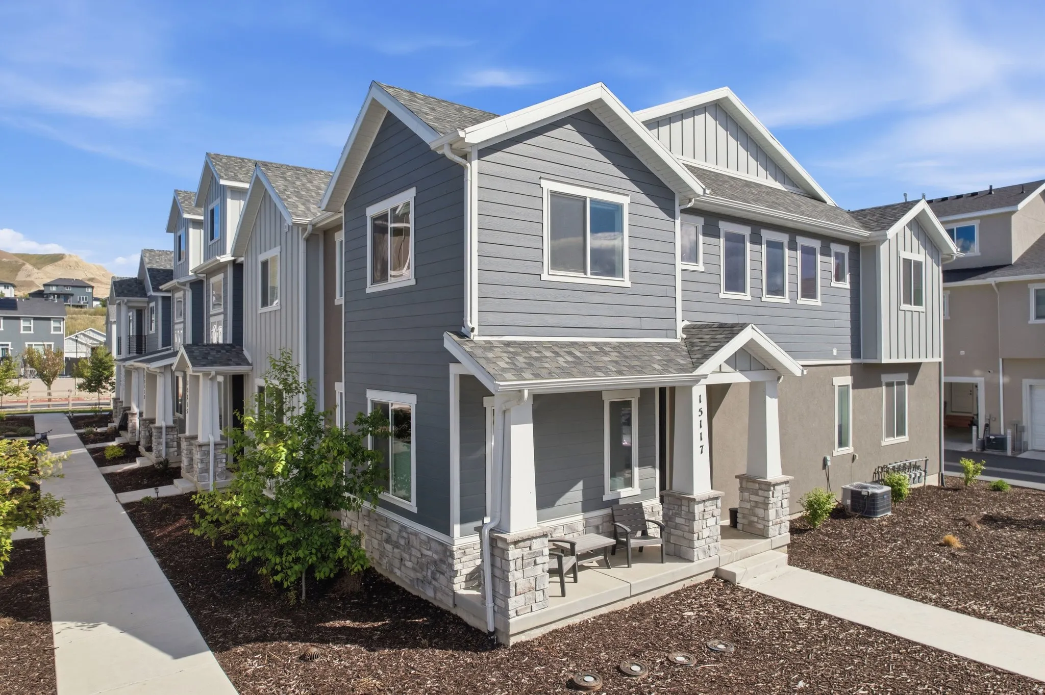 Craftsman inspired home with a residential view, board and batten siding, stone siding, covered porch, and a shingled roof