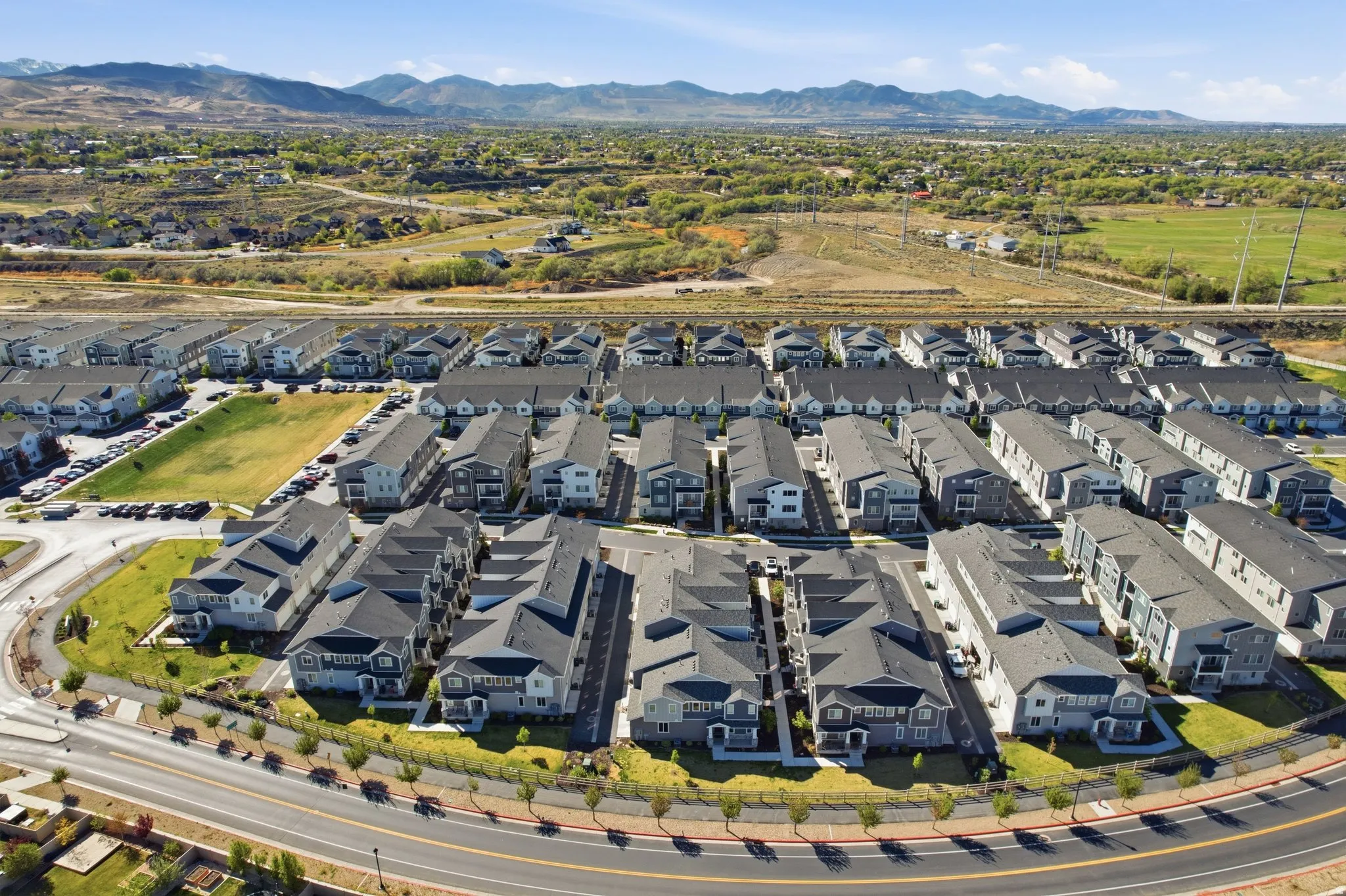 Aerial view of property and surrounding area featuring a mountain backdrop and nearby suburban area