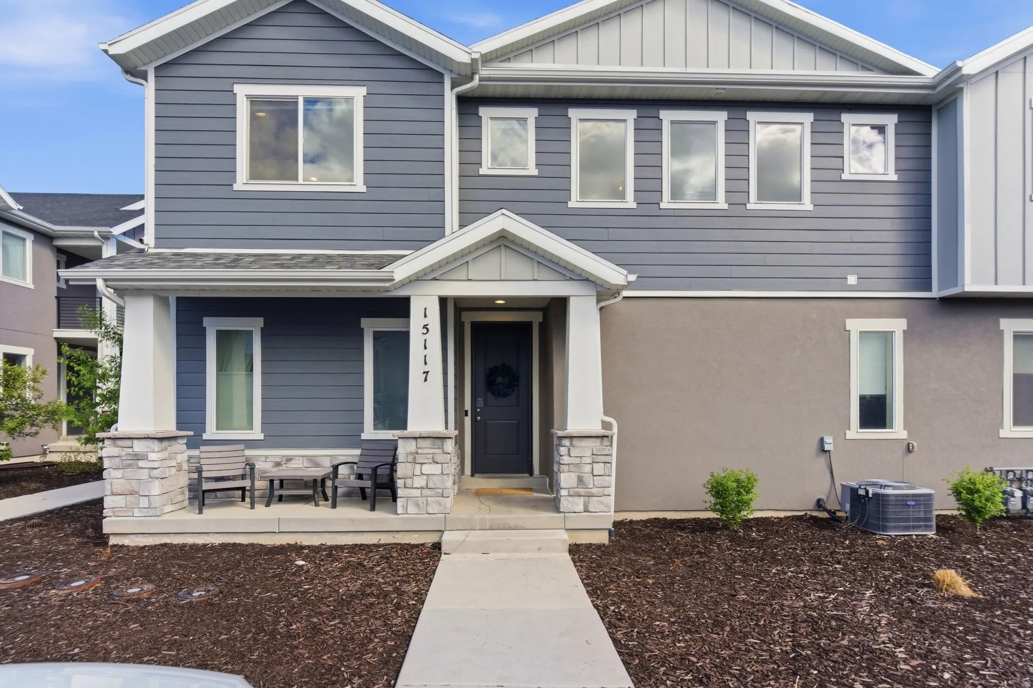 Craftsman-style house with stone siding, board and batten siding, and covered porch