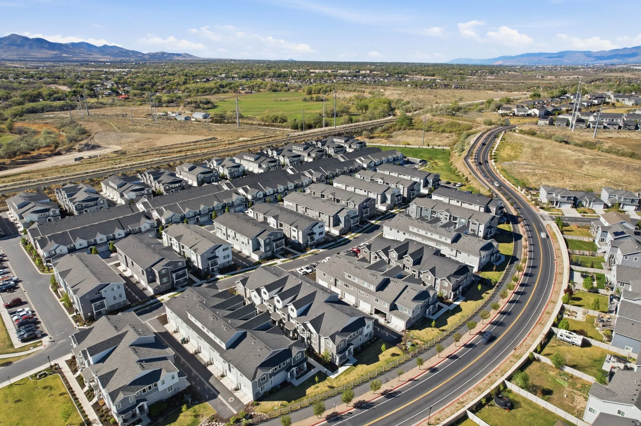 Aerial view of property and surrounding area with nearby suburban area and mountains