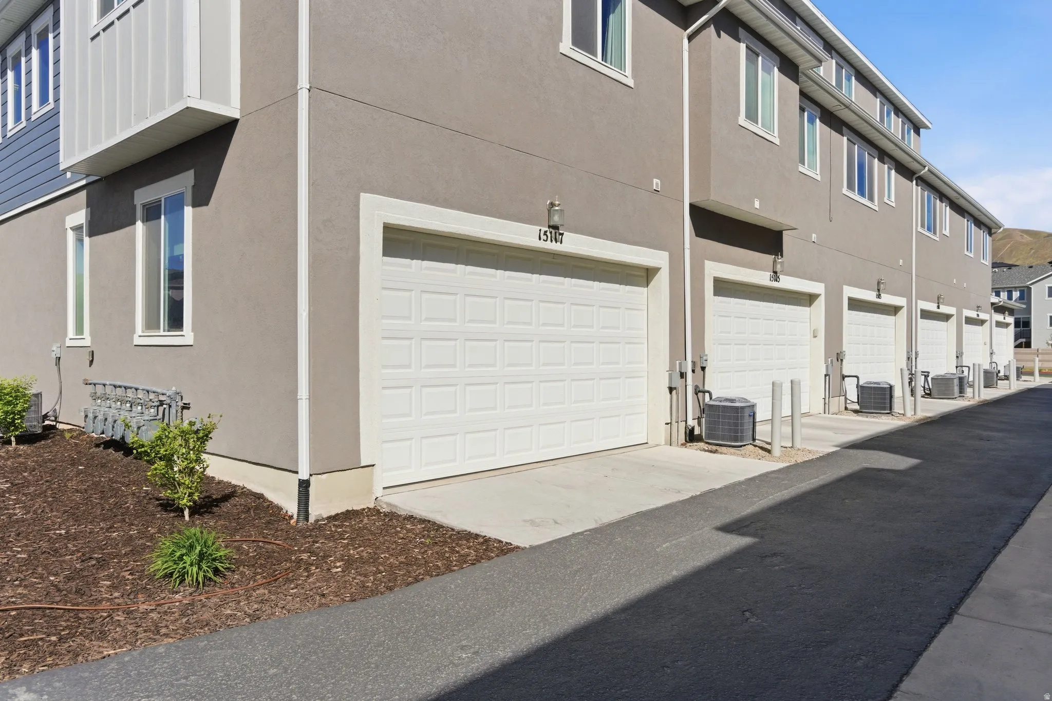 View of side of property featuring a garage, stucco siding, and driveway
