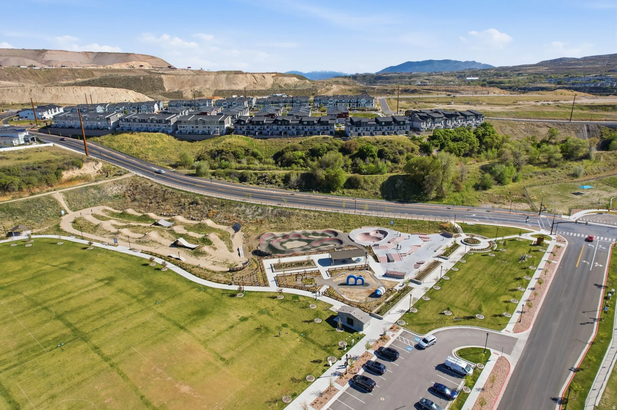 Aerial view of property and surrounding area featuring a mountainous background and nearby suburban area