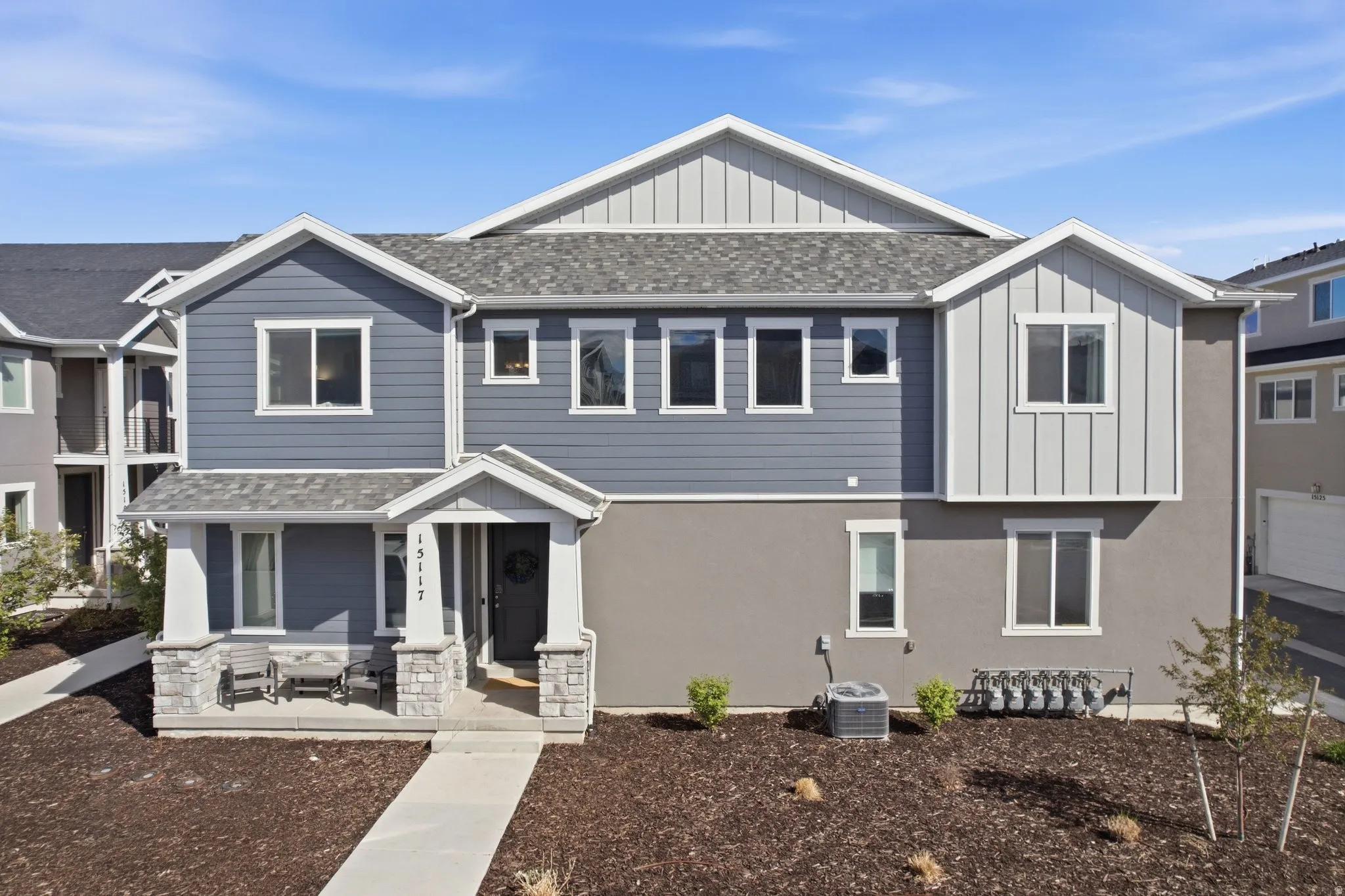 View of front of property with board and batten siding, a shingled roof, and stucco siding