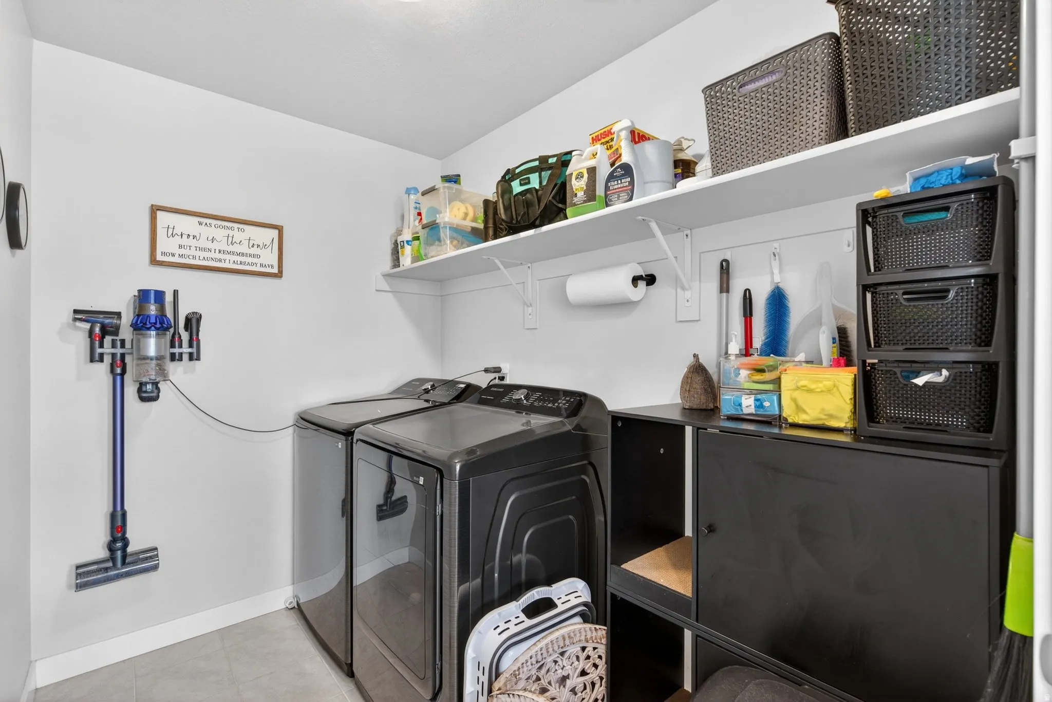 Laundry room with independent washer and dryer and light tile patterned floors