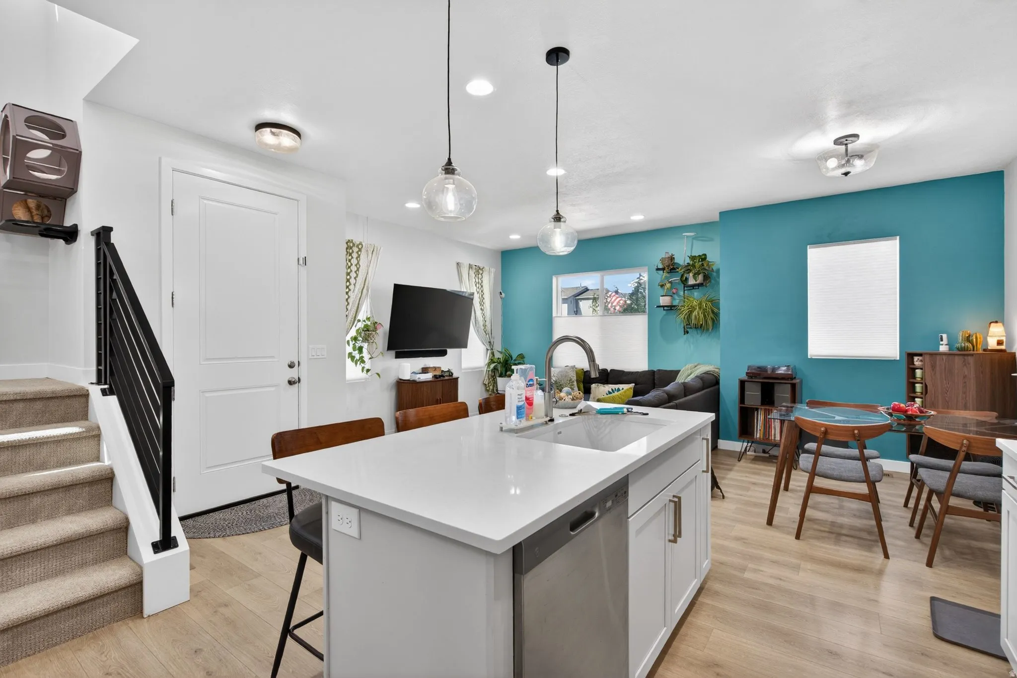 Kitchen with a breakfast bar, open floor plan, a center island with sink, and dishwasher