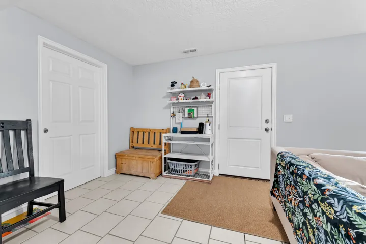 Interior space featuring a textured ceiling, light carpet, and light tile patterned floors