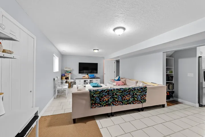 Living area with light tile patterned flooring and a textured ceiling