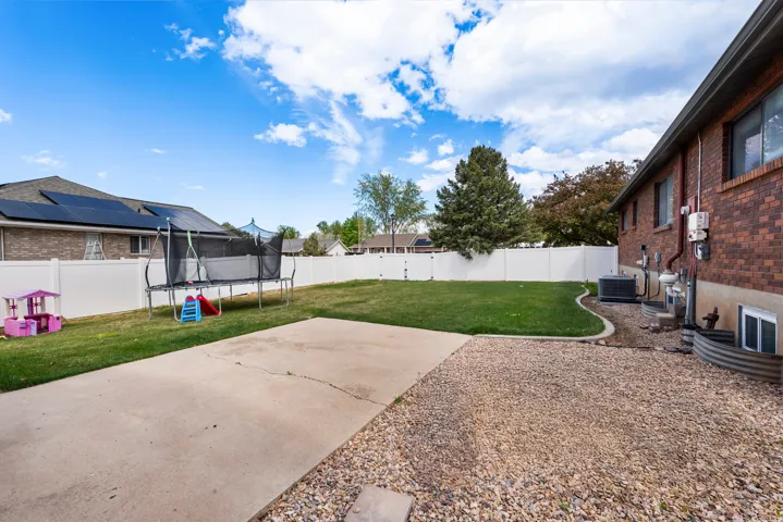 Fenced backyard with a patio and a trampoline