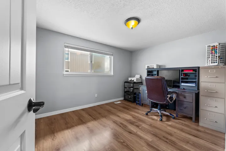 Office area featuring wood finished floors and a textured ceiling