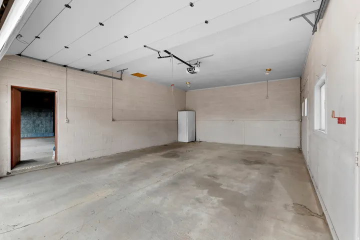 Garage with concrete block wall and freestanding refrigerator