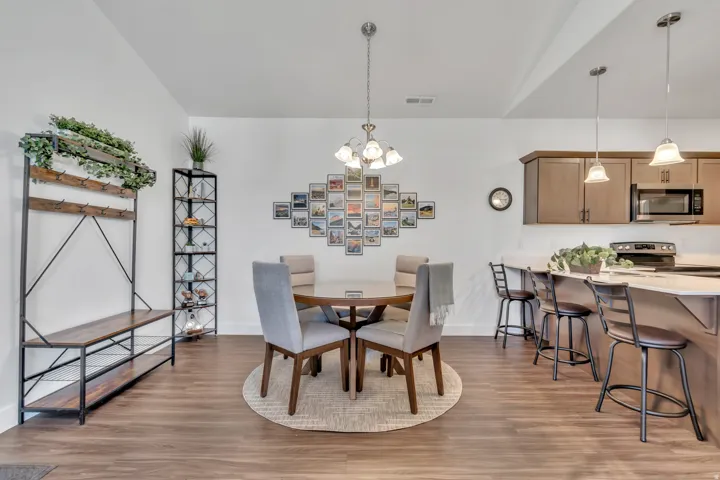 Dining room with light wood finished floors and hanging lights