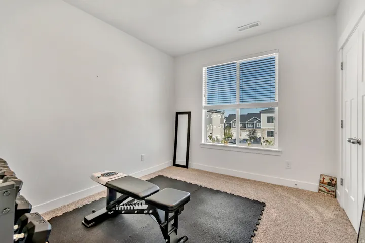 Exercise room featuring carpet and baseboards