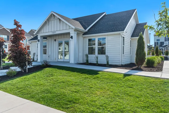 View of front of house featuring roof with shingles, a front yard, board and batten siding, and french doors