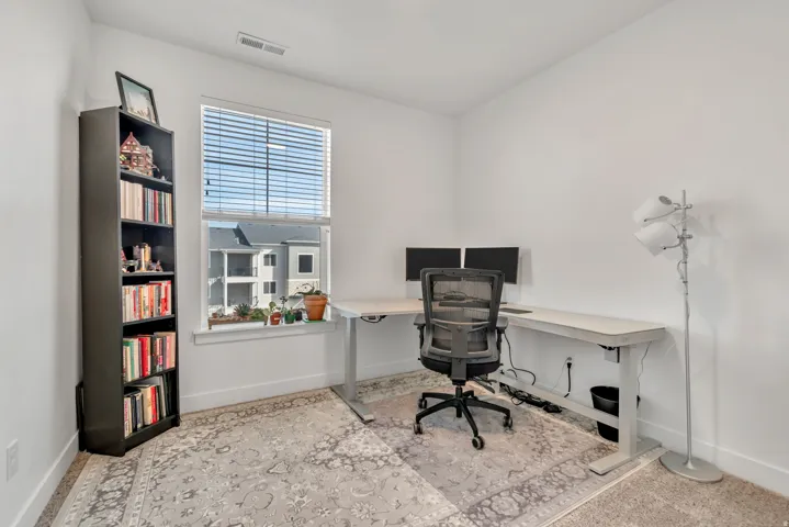 Office with baseboards and light colored carpet