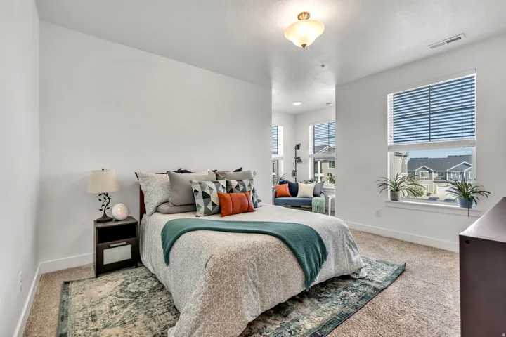 Bedroom with baseboards and light carpet