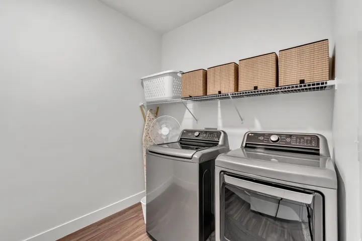 Laundry room with separate washer and dryer and light wood-style flooring