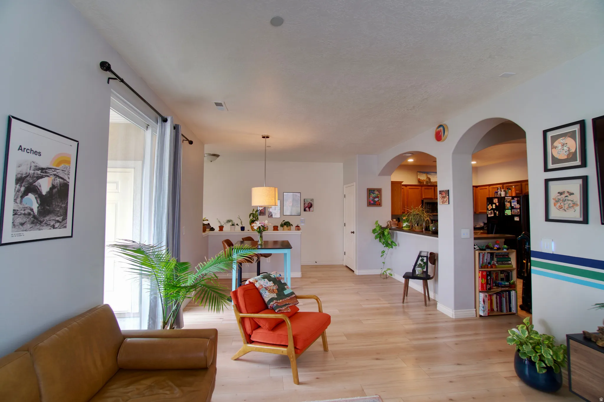 Living area featuring light wood-type flooring and arched walkways