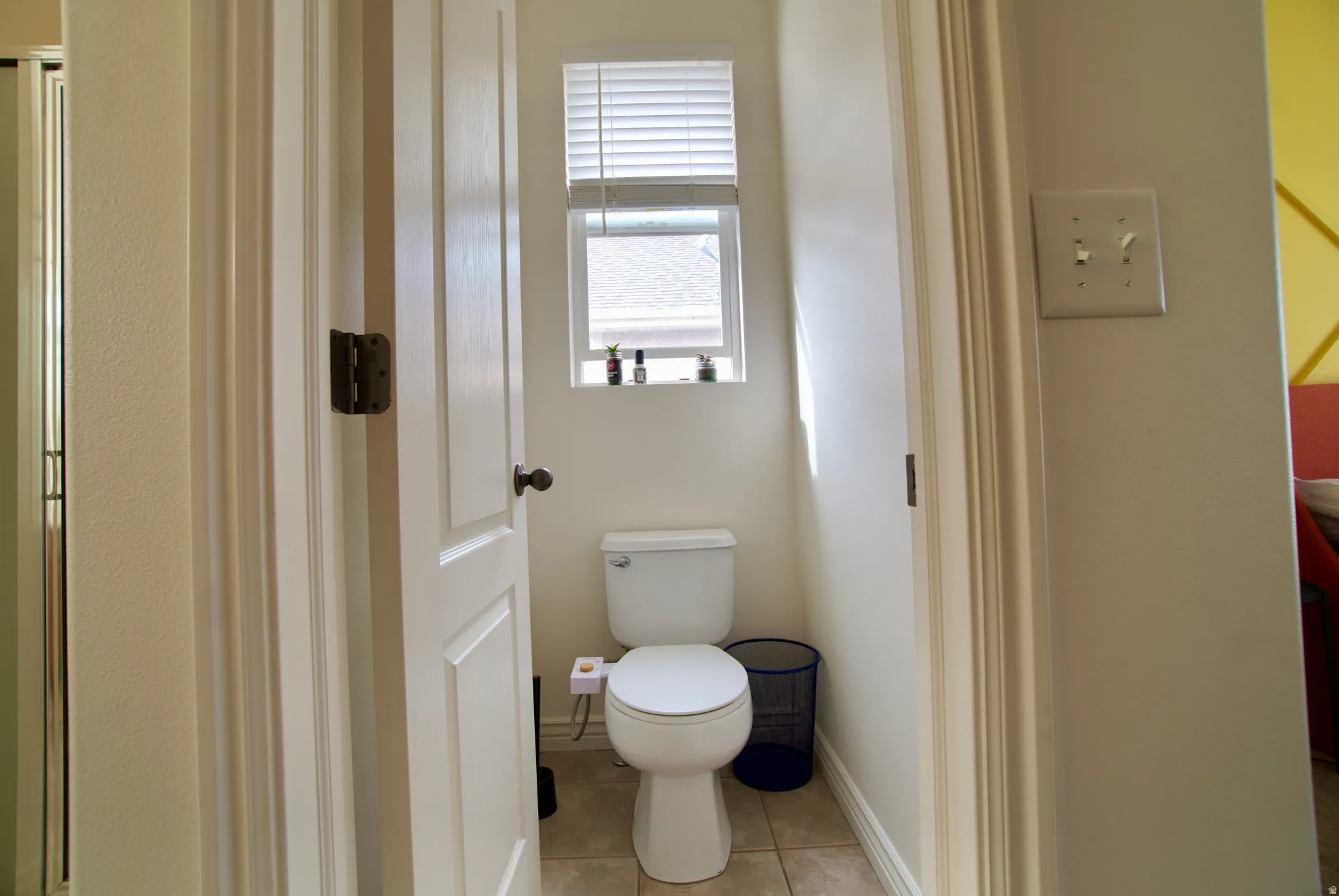 Bathroom with toilet and light tile patterned flooring
