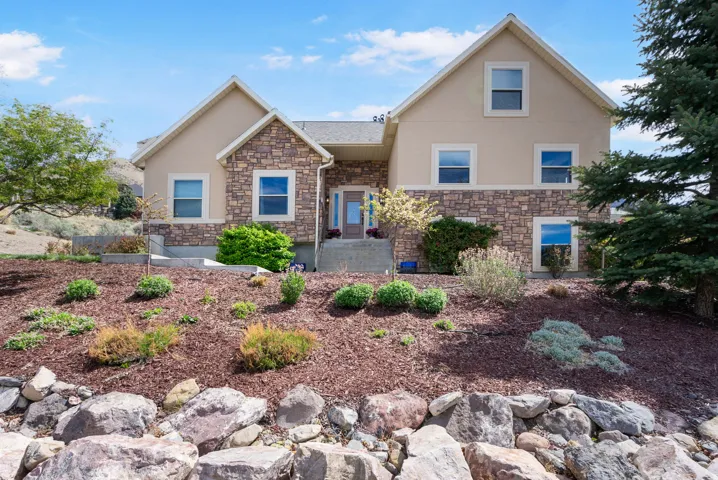 View of front of home featuring stone siding and stucco siding