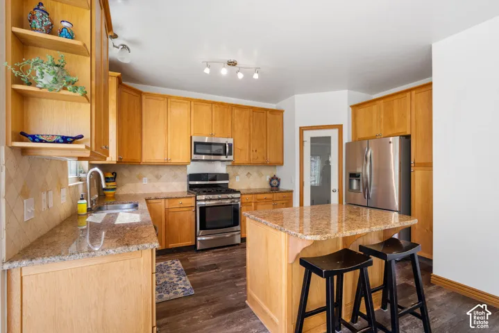 Kitchen with granite countertop, stainless steel appliances, and ample storage