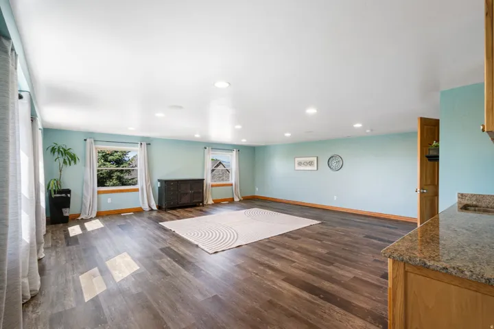 Unfurnished living room featuring recessed lighting and dark wood-style flooring
