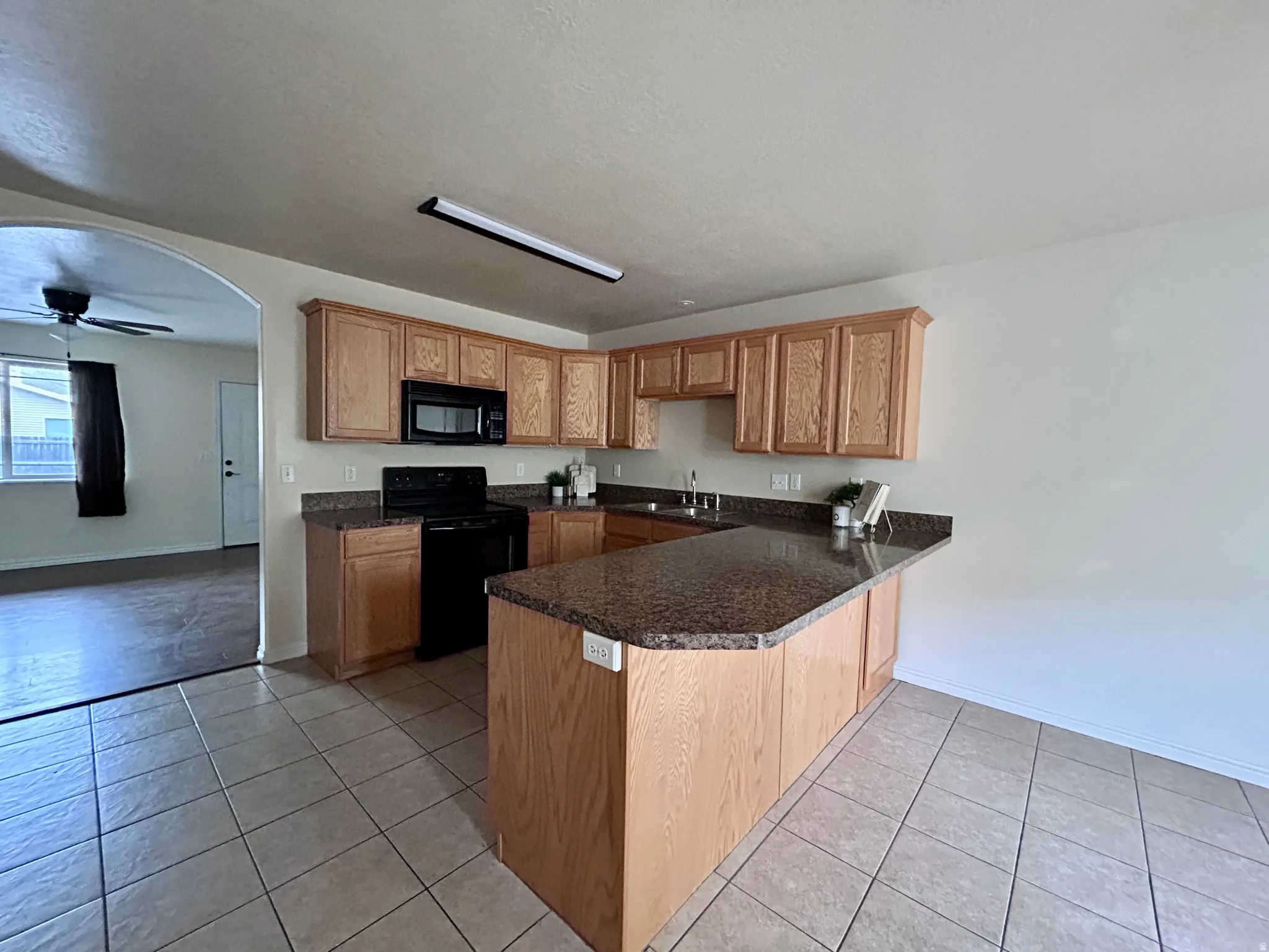 Kitchen with tiled floors and a large bar.
