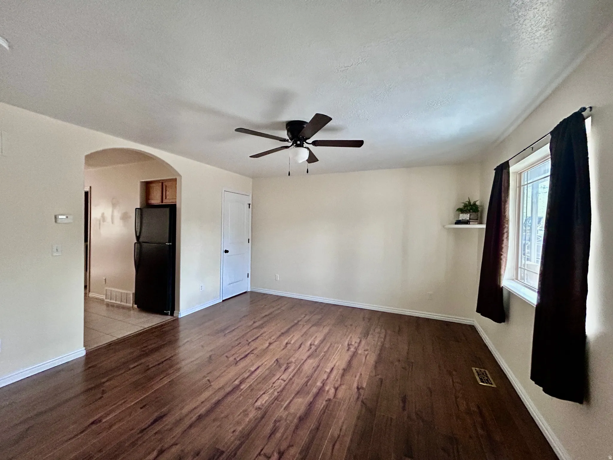 Living room with archway leading in to the kitchen.