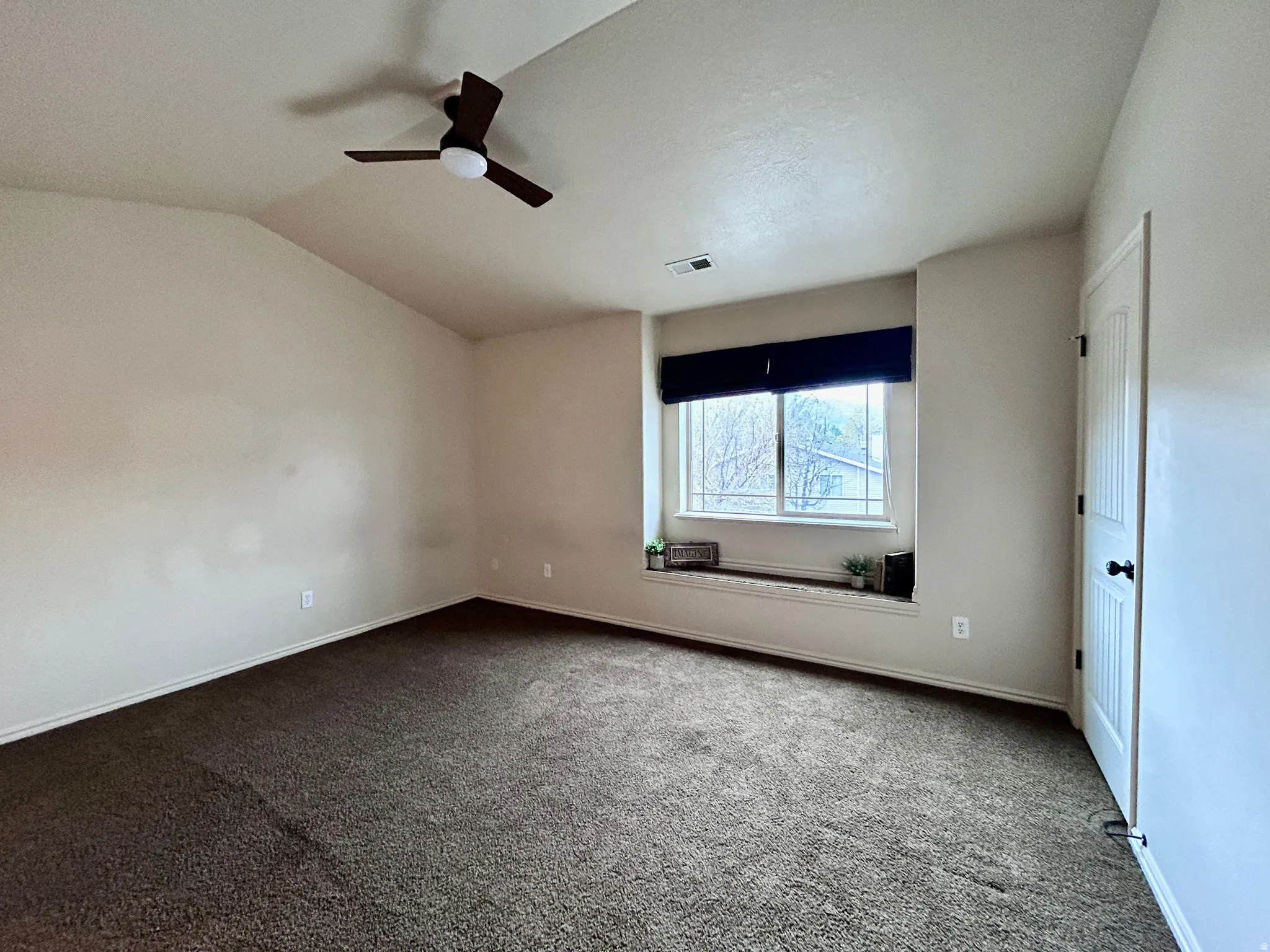 The spacious primary bedroom features vaulted ceilings.