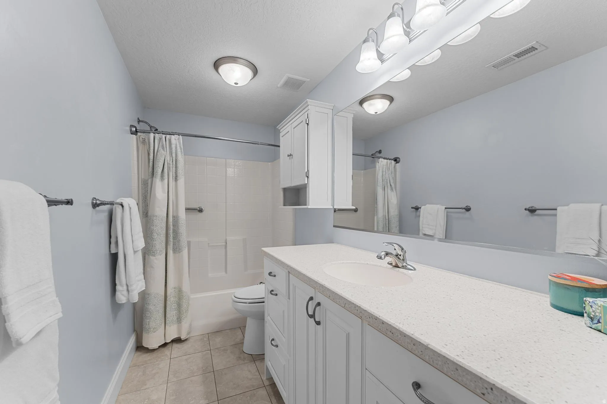 Bathroom with vanity, quartz  countertops, shower / bath combo