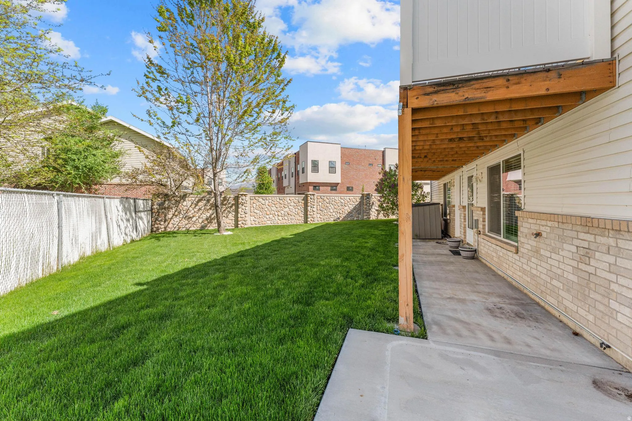 Partially fenced backyard with a patio