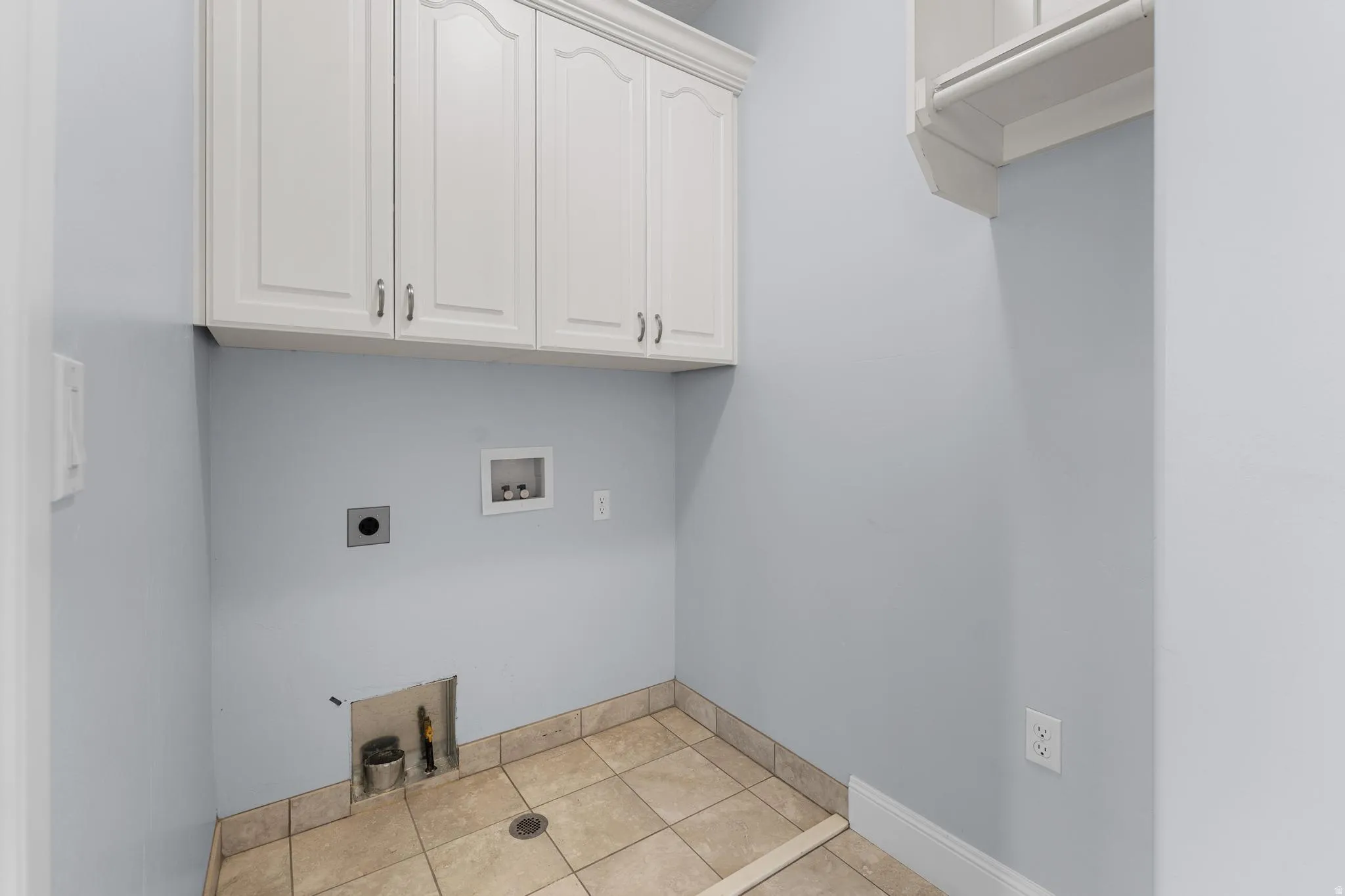 Laundry area with hookup for a washing machine,  electric/gas  dryer hookup, and cabinets