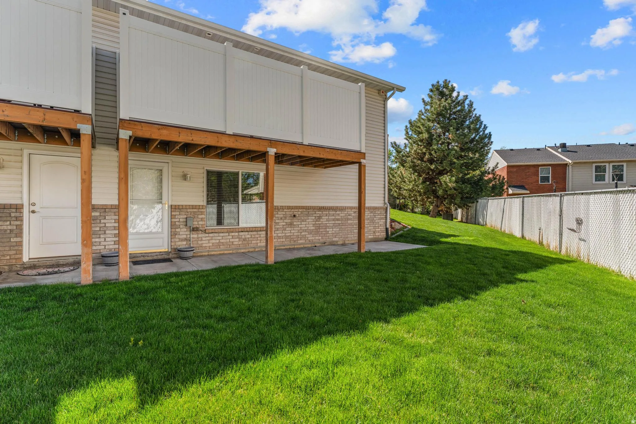Back of house with covered patio and brick siding