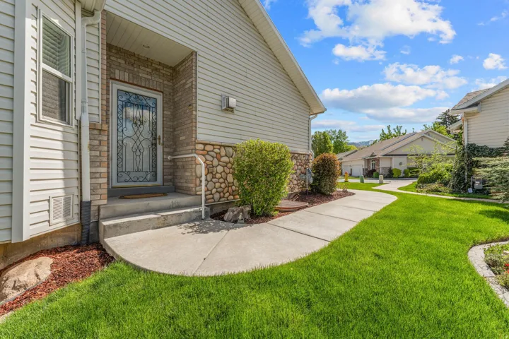 Property entrance featuring stone siding and a yard