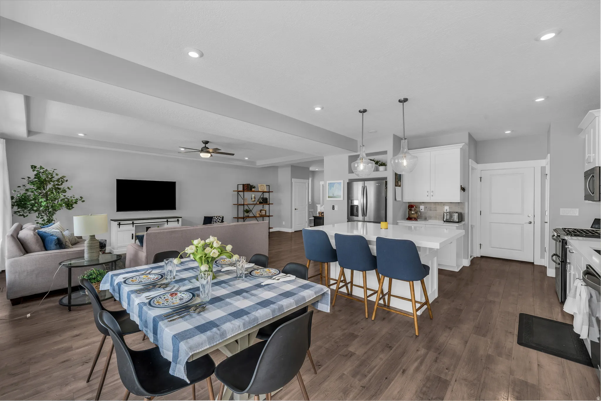 Dining area with dark wood-style floors, a ceiling fan, recessed lighting, and a tray ceiling
